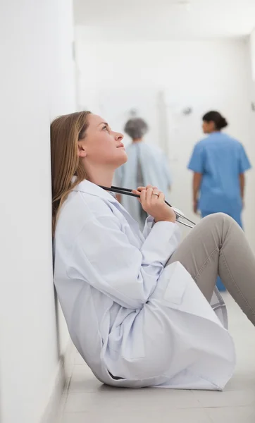 Medico premuroso seduto su un corridoio — Foto Stock