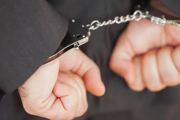 Hands in handcuffs clenching fists — Stock Photo, Image