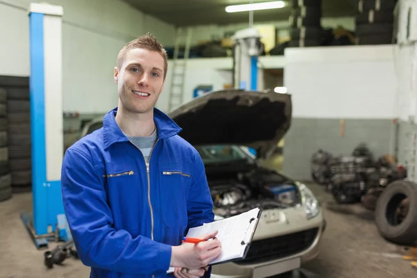 Mechanic writing on clipboard — Stock Photo, Image