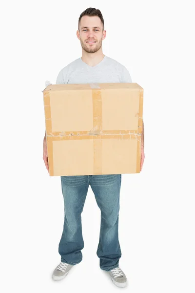 Retrato de jovem carregando caixa de papelão — Fotografia de Stock