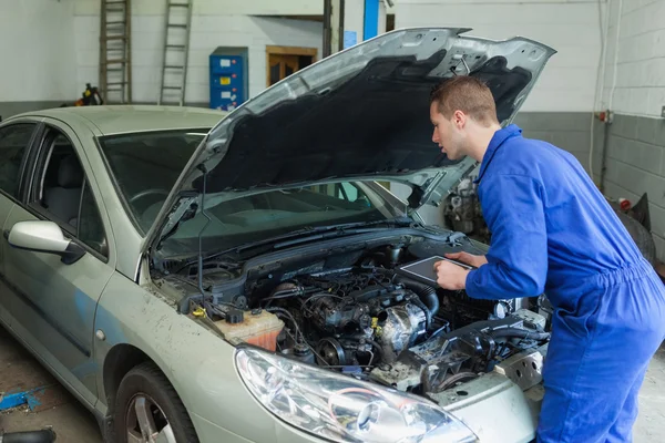 Mechanic analyzing car engine — Stock Photo, Image