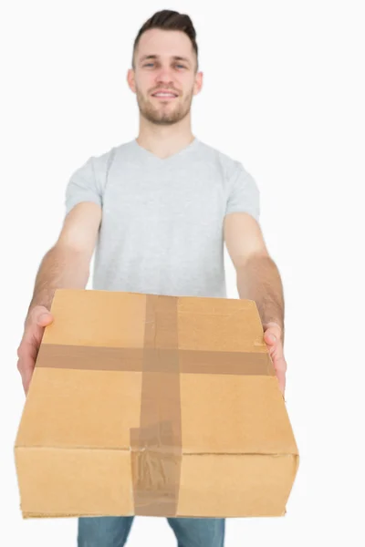 Portrait of young man giving you a package box — Stock Photo, Image