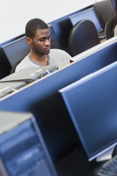 Człowiek siedzi w sali komputerowej — Zdjęcie stockowe