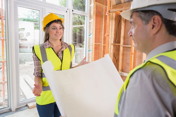 Woman and architect discussing blueprint — Stock Photo, Image