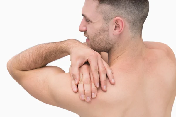 Rear view of shirtless man with shoulder pain — Stock Photo, Image