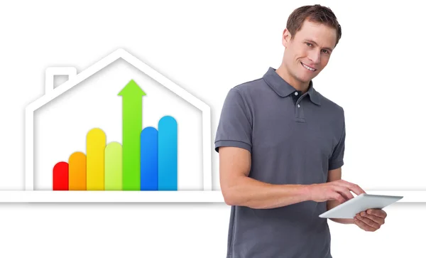Mann mit Tablet gegen energieeffiziente Hausgrafik — Stockfoto
