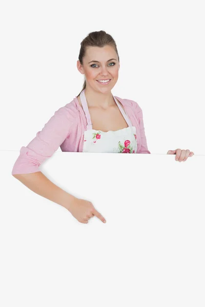 Bonne jeune femme de ménage pointant vers le panneau d'affichage — Photo