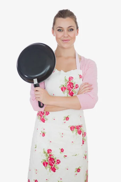 Молодая женщина со скрещенными руками держит сковородку — стоковое фото