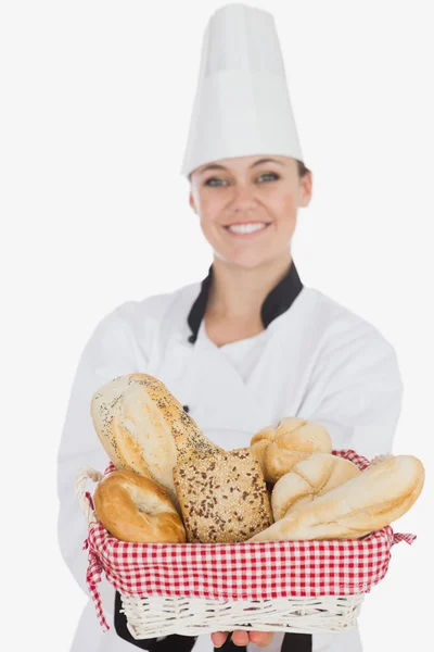 Young woman in chef uniform holding bread basket — Stock Photo, Image