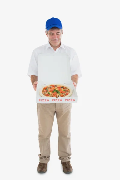 Mature delivery man looking at fresh pizza — Stock Photo, Image