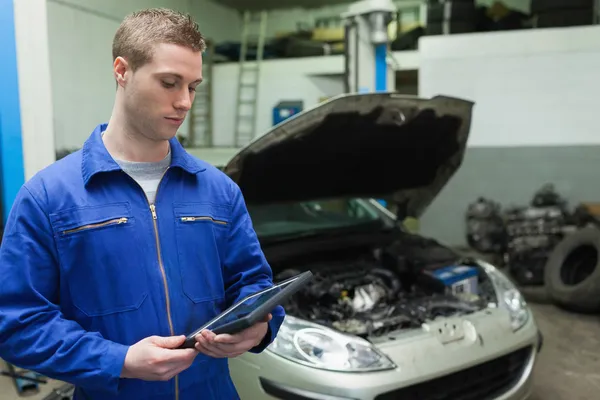 Mechanic kijken naar tablet pc — Stockfoto