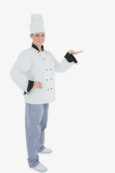 Portrait of female chef holding out your product — Stock Photo, Image