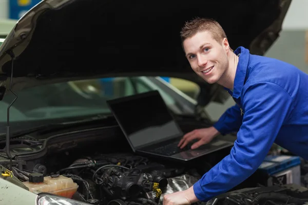 Gelukkig mechanic met behulp van laptop — Stockfoto