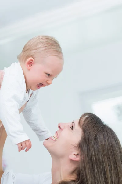 Mãe segurando seu filho enquanto sorri — Fotografia de Stock