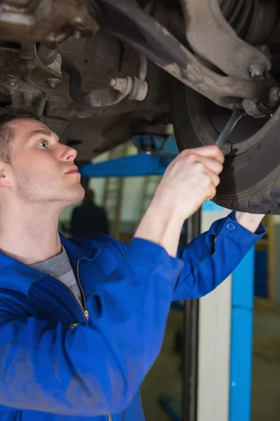 Man adjusting car tire with spanner — Stock Photo, Image