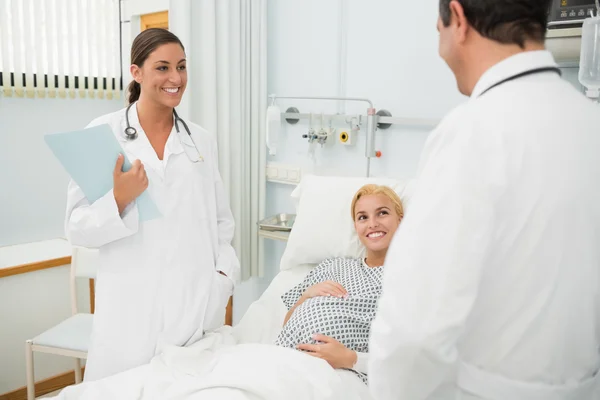 Vrouwelijke en mannelijke artsen naast een patiënt permanent — Stockfoto