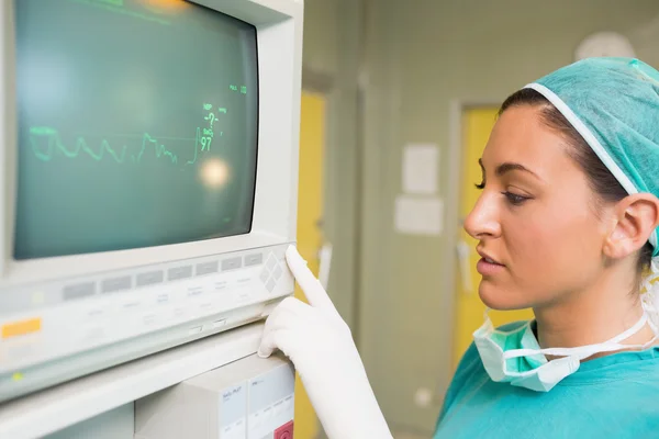 Smiling female surgeon standing next to a monitor — Stock Photo, Image