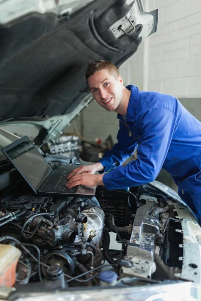 Mécanicien utilisant un ordinateur portable sur le moteur de voiture — Photo