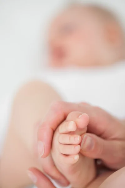 Pies de un bebé siendo tocado —  Fotos de Stock