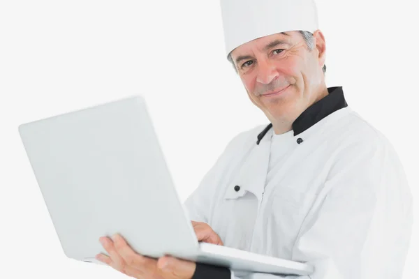 Mannelijke chef-kok met behulp van laptop glimlachen — Stockfoto