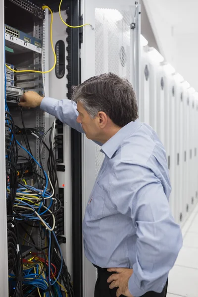 Técnico trabalhando em um caso de racks de servidor — Fotografia de Stock