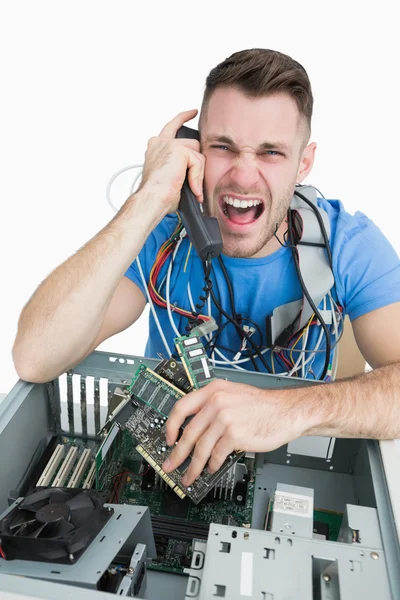 Frustrated computer engineer screaming over the phone in front o — Stock Photo, Image