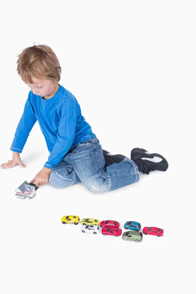 Jongen speelt met playhouse en speelgoed auto 's — Stockfoto