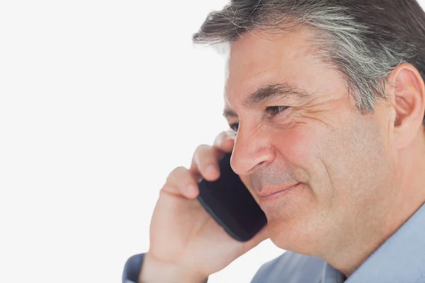 Mature businessman smiles while on call — Stock Photo, Image