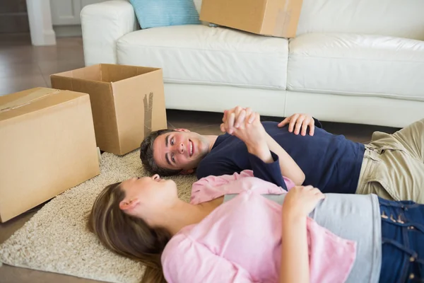 Couple lying on the floor with their moving boxes — Stock Photo, Image