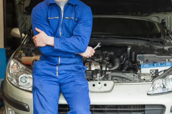 Mechanic leunend op auto met open kap — Stockfoto