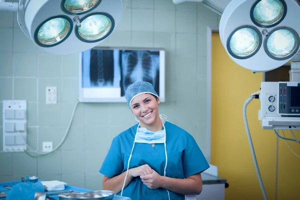 Улыбающийся хирург под хирургическим светом — стоковое фото