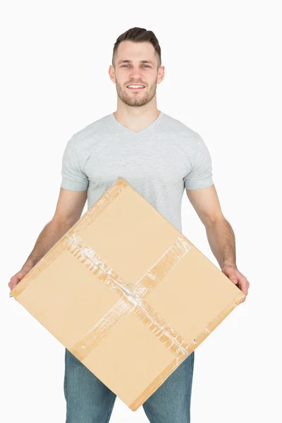 Portrait of young man carrying cardboard box — Stock Photo, Image