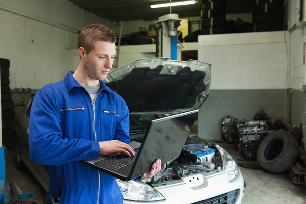 Mechanik za pomocą laptopa w garażu — Zdjęcie stockowe