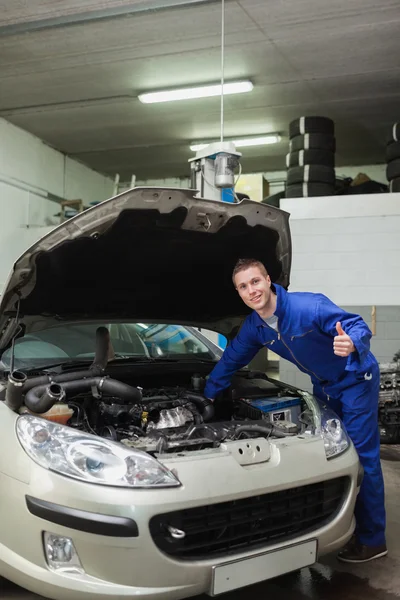 Mekaniker med bil ger tummen upp gest — Stockfoto
