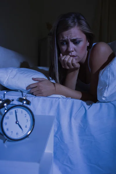 Беспокойная женщина в постели ночью — стоковое фото