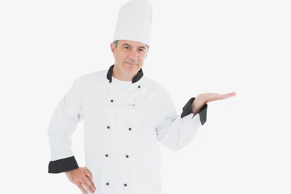 Зрілий шеф-кухар, що показує невидимий продукт — стокове фото