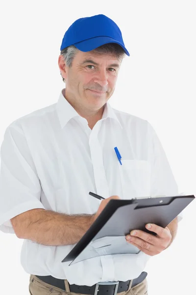 Confident courier man writing on clipboard — Stock Photo, Image