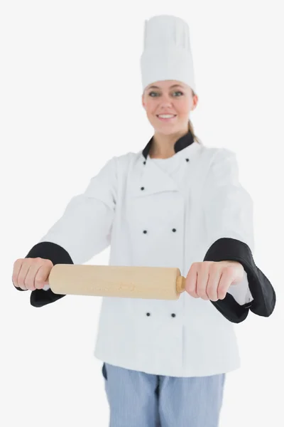 Happy woman in chef clothing holding rolling pin — Stock Photo, Image