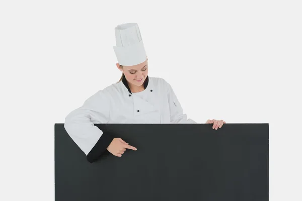 Femme dans les points de vêtements de chef au panneau d'affichage noir — Photo