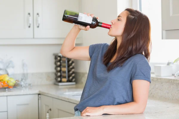 Женщина пьет бутылку вина одна — стоковое фото