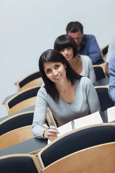 Mujer sonriente mirando hacia arriba de tomar notas —  Fotos de Stock
