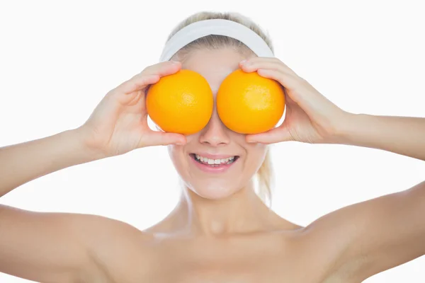 Ευτυχισμένη γυναίκα που κρατά τα πορτοκάλια μπροστά στα μάτια — Φωτογραφία Αρχείου