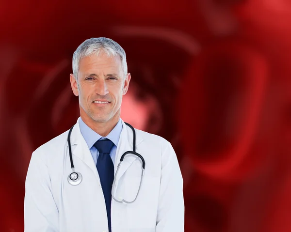 Médico em pé contra um fundo vermelho — Fotografia de Stock