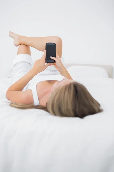 Lugn kvinna som tittar på sin telefon — Stockfoto