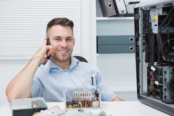Smiling computer engineer on call by open cpu — Stock Photo, Image