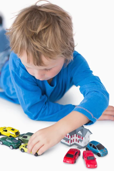 Nahaufnahme eines Jungen, der mit Spielhaus und Spielzeugautos spielt — Stockfoto