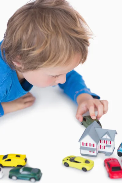 Close-up van jongen spelen met playhouse en speelgoed auto 's — Stockfoto