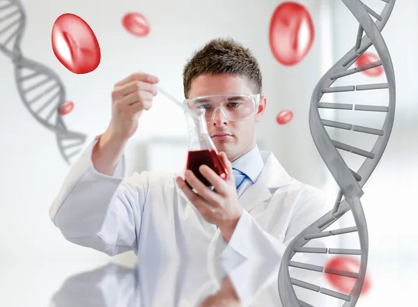 Serious chemist examining a beaker — Stock Photo, Image