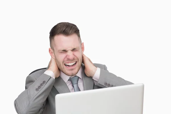 Business man suffering from severe neck pain while using laptop — Stock Photo, Image