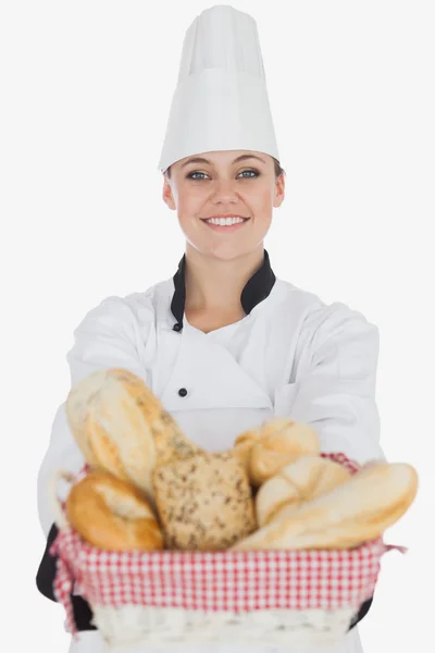 Happy young female chef with bread basket — Stock Photo, Image